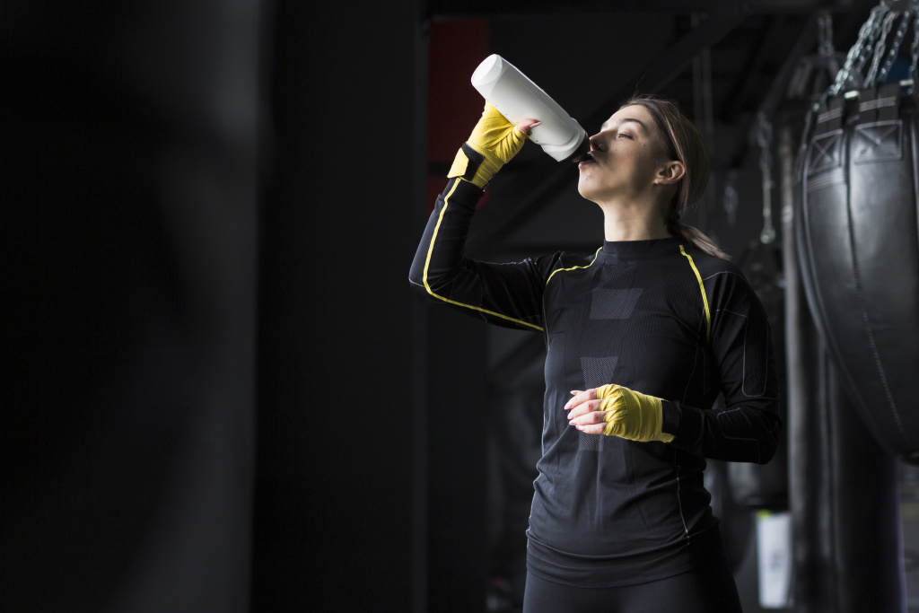 side-view-of-female-boxer-drinking-water-from-flask.jpg