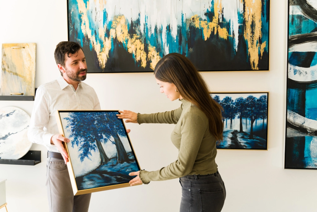 male-artist-showing-his-painting-female-client-interested-buying-some-artwork-from-exihibiton-art-gallery.jpg